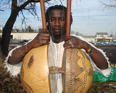 Sana Ndiaye posing with two ekontings, Musician, 2007; Sana Ndiaye; Northampton, Massachusetts;