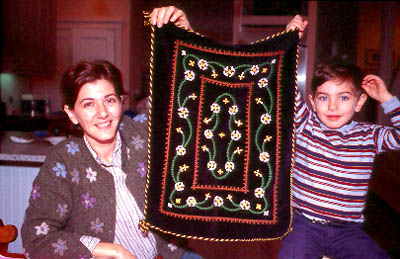 Nairi Havan holding mother's embroidery with her son; Armenian embroidery; 2002: Lexington, Massachusetts
