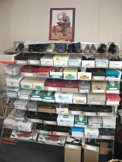 Boxes of shoes in the Poitras Cobbler Shop; Custom built shoes; 2012: Lowell, Massachusetts