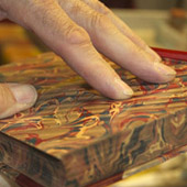 Dan showing edge marbling on book; Paper marbling; 2014: Amherst
