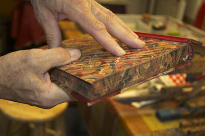 Dan showing edge marbling on book; Paper marbling; 2014: Amherst